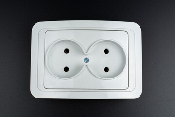 close-up of white electrical outlet on black background