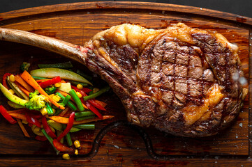 Tomahawk steak and veggies on a serving board