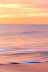 abstract landscape of sea. texture water, sky and sand in blurry motion in tropical sunset colors