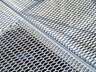 Perforated metal sheet stamping plates texture angled view. Made through metal stamping sheet metal manufacturing lightweight elements to combine loadbearing structural strength functionality.