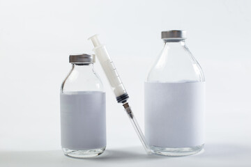 Vaccine and syringe. Medical glass containers on a white background.