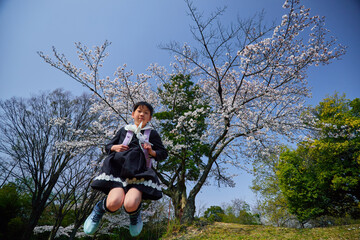 桜満開の公園で遊んでいる小学生の新入生の様子