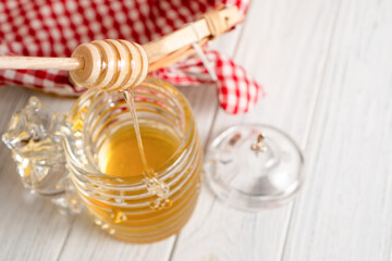 Honey background. Sweet honey in the comb, glass jar. Pouring aromatic honey into jar. Honey background