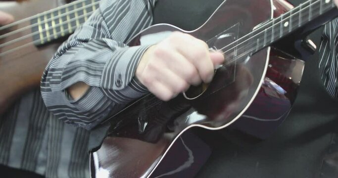 Guitarist Playing Four String Guitar in Party Band