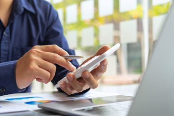 Male accountants or businessmen use a calculator and laptop to calculate investment results. And making financial reports on the desk Business finance accounting concept