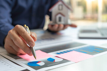 The hand of a male accountant or businessman examining the investment results. And making financial...