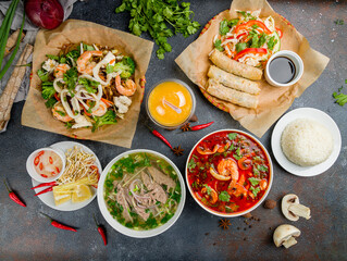 Assorted asian dinner, vietnamese food. Pho bo, pho tom, noodles, spring rolls, tom yam, rice,...
