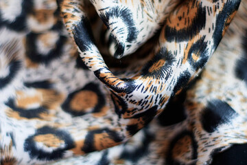 Satin fabric close up background and texture with place for text. Leopard print, silk orange.