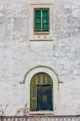 Fototapeta na wymiar Old green windows on a white wall