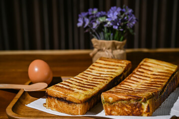 Bread toast and an egg close up view with decorative plant on wooden table