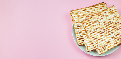 Matzo on a pink background. Traditional Jewish food.  for  regilious spring holiday of Pesach. Happy Passover. Copy space.
