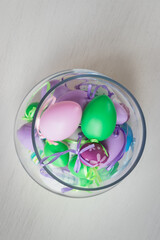 Glass vase filled with colorful Easter eggs 