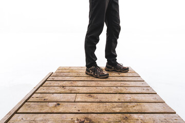 Man standing on a wooden bridge in the fog