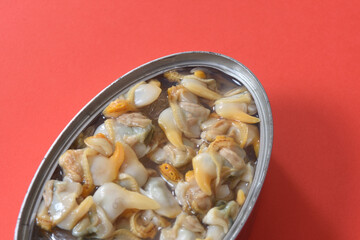 close up of a can of pickled mussel on red background