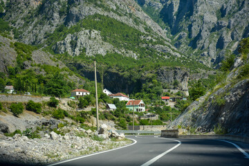 Kleines Bergdorf bei Selce mit Passstraße und Berge im Hintergrund im Vermosh in Albanien