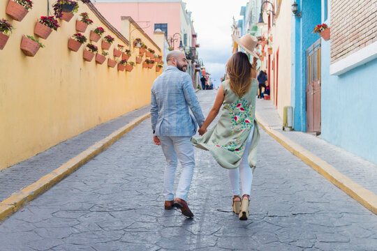 Pareja vacacionando en mexico con pueblo magico de fondo