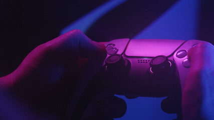 Gamer`s playing a game with a gamepad controller. Game man holding simulator joystick. Close up. Holding simulator joystick. Colorful fashion neon style © MIKHAIL