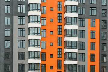 The facade of a multi-storey building with windows and balconies as an element of the architecture of a modern city