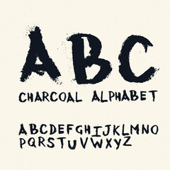 Charcoal handwritten alphabet. On textured paper with crumbling particles.