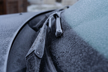 Windshield wipers in a car covered with frost in the morning of winter