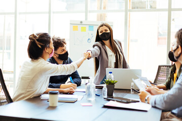 Business team wearing protective masks while meeting in the office during the COVID-19 epidemic