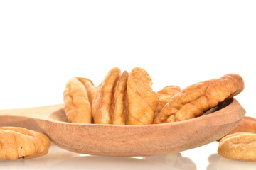 Several light brown organic peeled pecans with a wooden spoon, close-up, isolated on white.