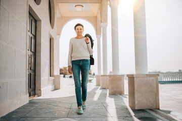 A young woman walks along the embankment