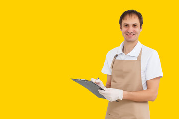 young man in white t-shirt uniform holding clipboard isolated over yellow background. express delivery concept