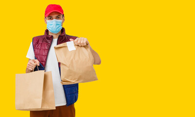 Fototapeta na wymiar Delivery man employee in mask glove hold craft paper packet with food isolated on yellow background studio Service quarantine pandemic coronavirus virus 2019-ncov concept