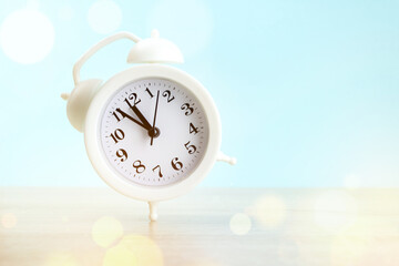 Running white alarm clock on light background. Time is running out concept.