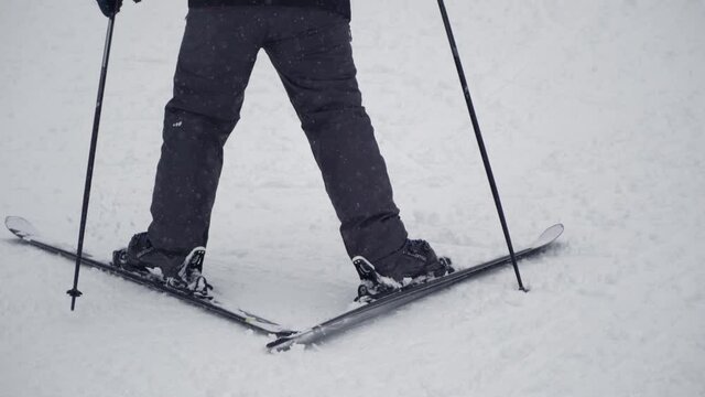 Skier walking up a mountain towards the ski lodge with skis on