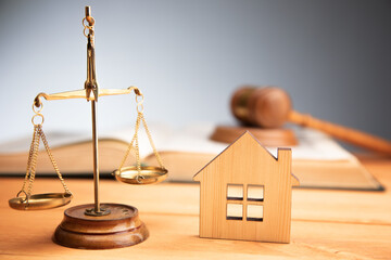 house model with gavel, scales of justice and book