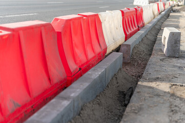 Replacement of curbs along the road and fencing made of plastic water barriers