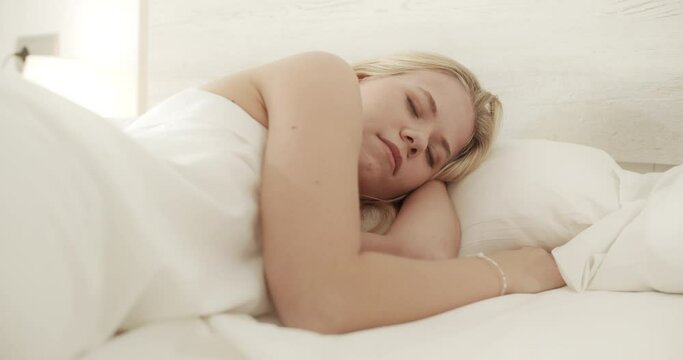 Blonde Young Woman Peacefully Sleeping in Airy Bedroom