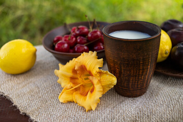 glass of milk, lemon and cherries