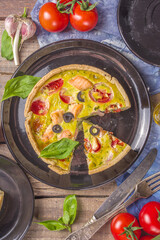 Homemade quiche Lorraine , savory pie with salmon fish, broccoli, spinach and tomatoes, on wooden table background copy space