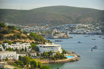 Fototapeta na wymiar Panoramic View of Aegean sea, traditional white houses marina and Bodrum Castle in Bodrum city of Turkey. Aegean traditional style architecture. Bodrum bay. View from hight