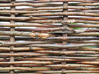 Dense rows of grey weathered willow reeds in an irregular pattern at an fence panel - 423250772