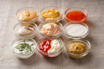 Assortment of sauces. A set of different sauces on the table is covered with a light linen cloth.