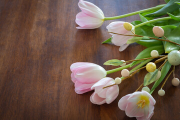 pink tulips with easter egg decoration on wood