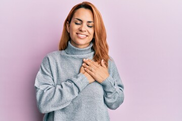 Hispanic young woman wearing casual turtleneck sweater smiling with hands on chest, eyes closed with grateful gesture on face. health concept.