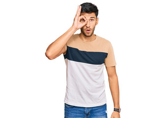 Fototapeta premium Young handsome man wearing casual clothes doing ok gesture shocked with surprised face, eye looking through fingers. unbelieving expression.