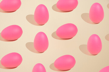 2021 Easter bold and minimal still life composition. Pink eggs arranged on beige background. Trendy minimal concept.