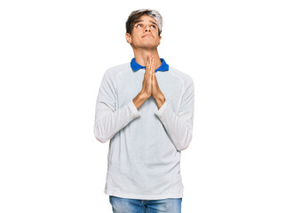 Young hispanic man wearing casual clothes begging and praying with hands together with hope expression on face very emotional and worried. begging.