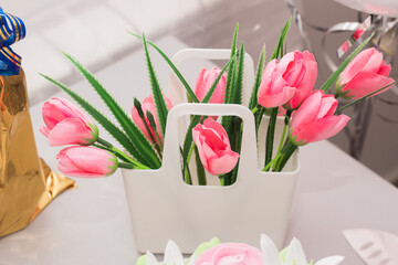 Artificial pink flowers in a basket