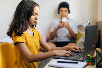 Two preteens at home browsing the internet.