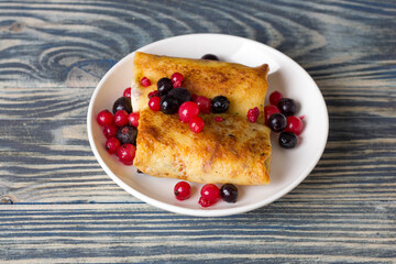 Rolled thin pancakes stuffed with cottage cheese and berries