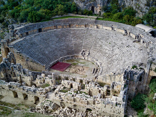 High angle drone aerial view of ancient greek rock cut lykian empire amphitheatre and tombs in Myra...