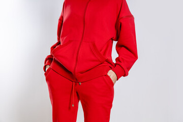 front view of a girl in a red tracksuit on a white background