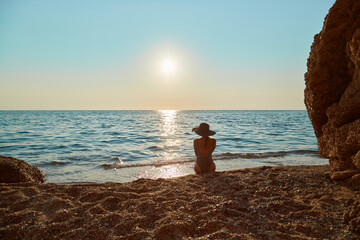 Girl watch sunset over sea. Beautiful landscape on beach. Time to relax, summer time and holiday trip idea, copy space